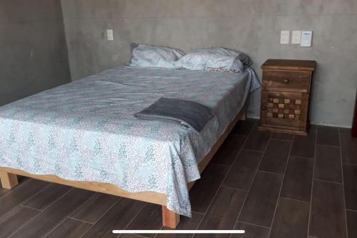 GaritaLees' Beach House的一间卧室配有床和木制床头柜