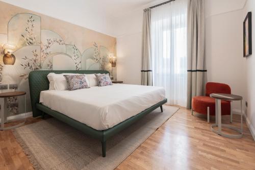 罗马Be Mate Trastevere II的一间卧室配有一张大床和一张红色椅子