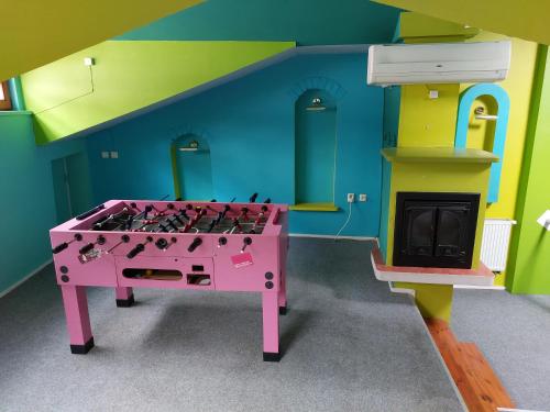 维尔纽斯25 Hours Hostel的一间带粉红色桌子和壁炉的腿部客房