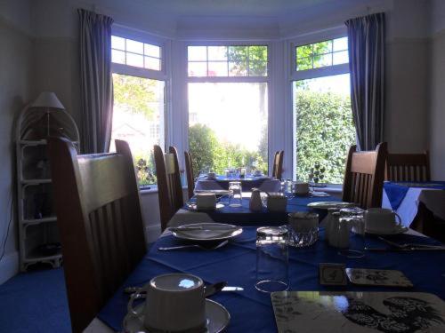 兰迪德诺Cleave Court Guest House的一间用餐室,配有一张带蓝桌布的桌子