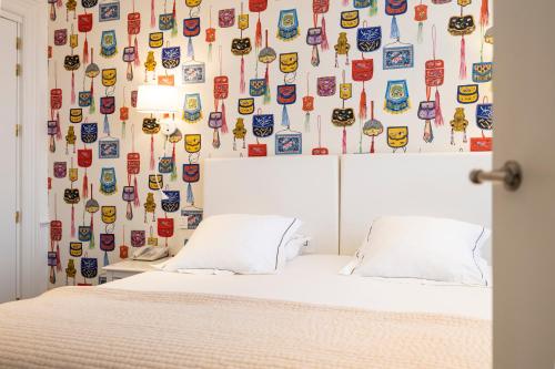 布鲁塞尔路易丝酒店的一间卧室配有一张带挂在贴纸上的墙壁的床