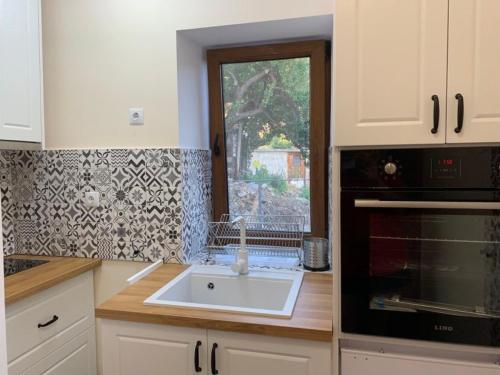 BorowoКъща за гости Вино от глухарчета的厨房设有水槽和窗户。
