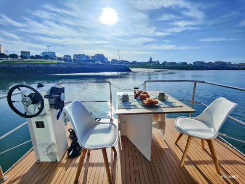 波瓦-迪瓦尔津Floating Experience - Casa flutuante a 25 min do Porto的船上的桌椅