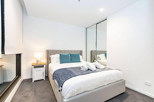 墨尔本Relaxing Urban Oasis的一间卧室配有一张带蓝色枕头和镜子的床