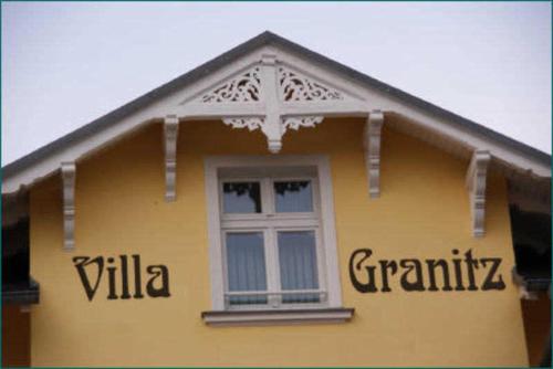 奥斯特巴德·哥伦Villa Granitz - Ferienwohnung 45463的黄色的房子,房子的一侧有窗户