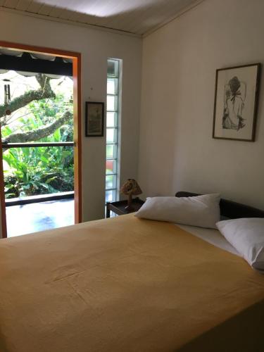 乌巴图巴Casa da árvore的一间卧室设有一张大床和一个窗户。