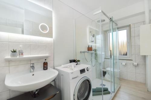 居特斯洛Gemütliche & stylische Wohnung - Küche - Wifi - TV的白色的浴室设有水槽和淋浴。