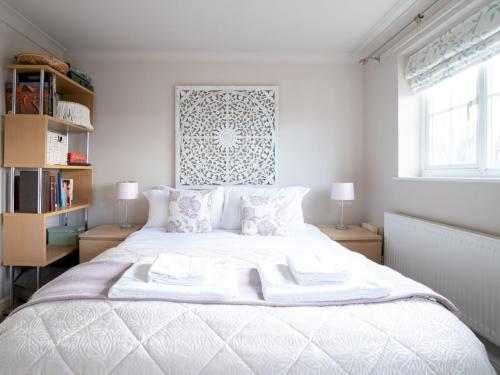 马姆斯伯里Historic Malmesbury - Delightful home with parking的一间卧室配有一张带两盏灯的大型白色床。