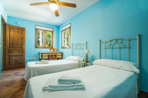 卡尔佩Villa Cintya - PlusHolidays的蓝色墙壁客房的两张床