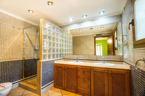 卡尔佩Villa Cintya - PlusHolidays的一间带两个盥洗盆和淋浴的浴室