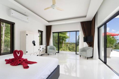 茶云莱海滩paradise sea view infinity Pool Villa Chaweng Koh Samui的一间卧室配有一张红色带子的床