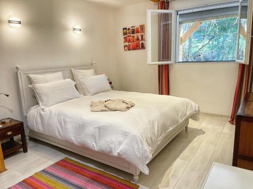 维伊勒佩Appartement au calme avec terrasse verdoyante entre Annecy et Genève的一间卧室配有一张带白色床单的床和一扇窗户。