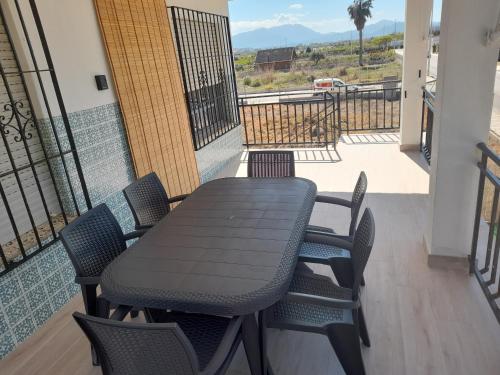 贝利雷瓜尔德Apartamentos playa de bellreguard,gandia,oliva,denia,benidorm的阳台上配有一张黑色的桌子和椅子