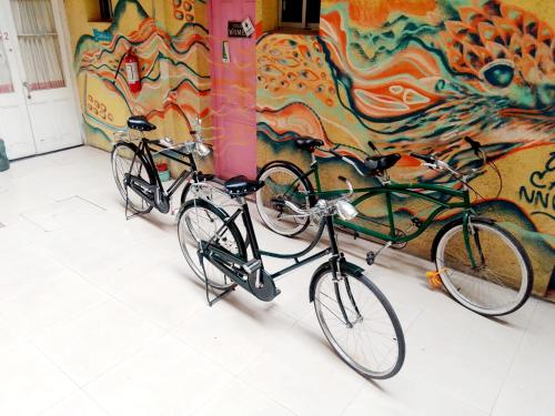 蒙得维的亚Montevideo Port Hostel的两辆自行车停在墙上,墙上挂着一幅画