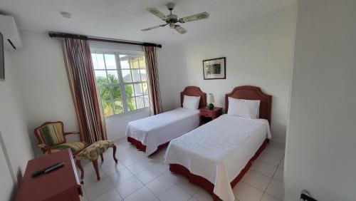 圣玛丽Sea Palms Beach Holiday的一间卧室设有两张床和窗户。