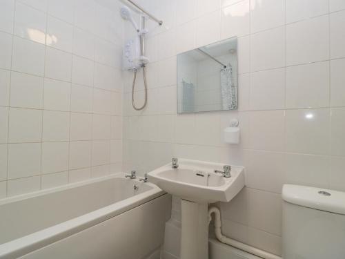 韦茅斯Lodmoor House的白色的浴室设有水槽、浴缸和卫生间。