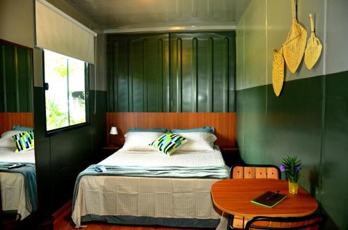 贝卢港Innbox - Porto Belo的一间卧室设有两张床和一张木桌