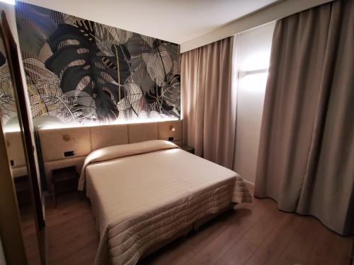 佛罗伦萨贝尔科尼酒店的卧室配有一张床,墙上挂有绘画作品