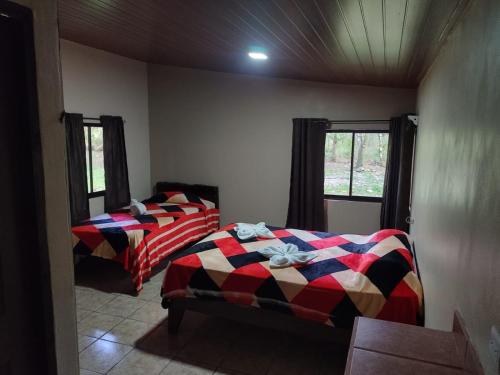 比加瓜Nacientes Lodge的带2扇窗户的客房内的2张床