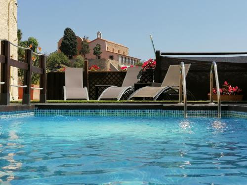 Premia de Dalt卡尔音乐住宿加早餐旅馆的一个带白色椅子的游泳池和一个游泳池
