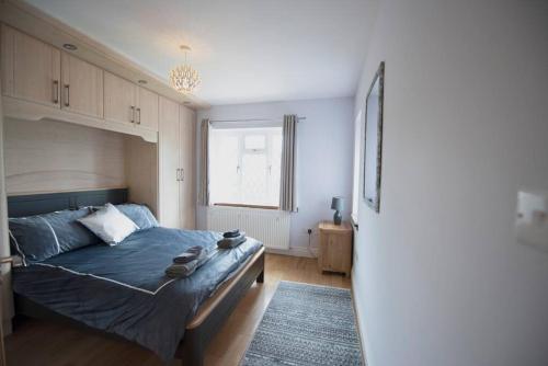 诺斯伍德Luxury 6 bedroom house with parking - Northwood的一间卧室设有蓝色的床和窗户。