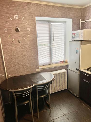 切尔尼戈夫Апартаменты в самом Центре прПобеды 90的厨房配有桌子和冰箱