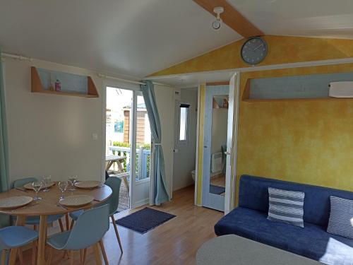 Biville-sur-MerLA CASA的客厅配有桌子和蓝色沙发