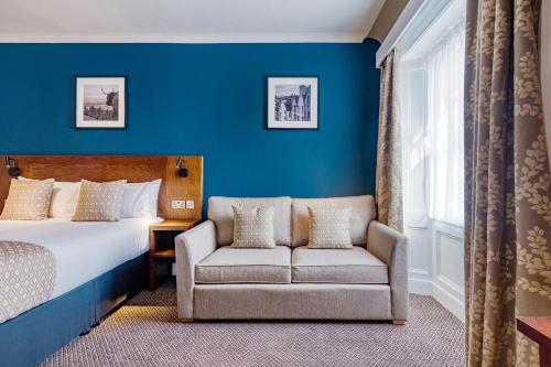 爱丁堡Toby Carvery Edinburgh West by Innkeeper's Collection的配有一张床和一把椅子的酒店客房