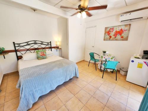 塔沃加Cerrito Tropical Eco Lodge的一间卧室配有一张床和一张桌子及椅子