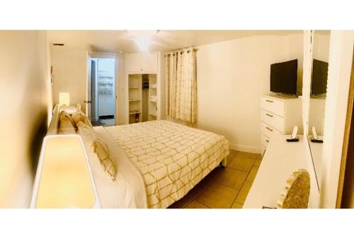 劳德代尔堡PRIVATE Cozy Guest Suite Near Hard Rock Guitar的一间卧室配有一张床、梳妆台和电视。