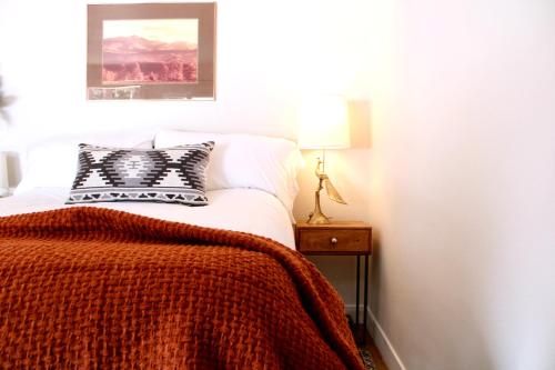 埃斯蒂斯帕克Kinnikinnik Motor Lodge的一间卧室配有一张带橙色毯子的床