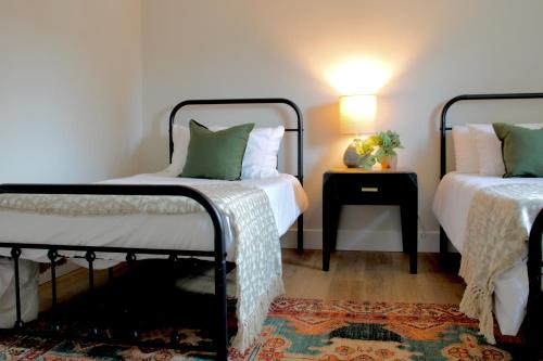 埃斯蒂斯帕克Kinnikinnik Motor Lodge的一间卧室配有两张床和一个带灯的床头柜