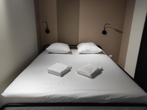 马洛塞讷Apparts'hôtel la ferme du gros noyer的一张带两个枕头的大白色床