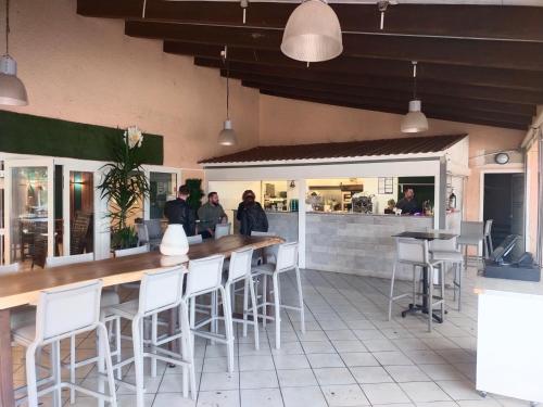 瓦尔拉普拉日MOBIL HOME LE STEPHANOIS VALRAS的餐厅设有酒吧,配有白色凳子