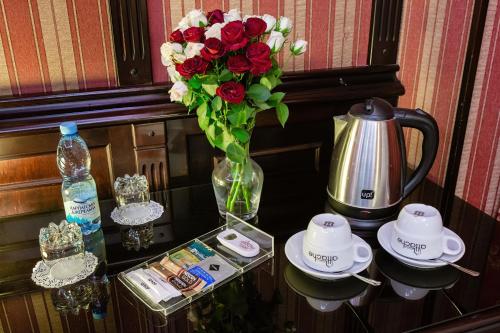 基辅Tiso Apart Hotel的一张桌子,上面有玫瑰花瓶和茶具