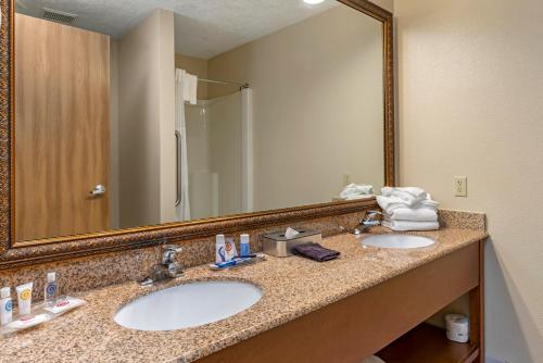 塞勒姆康福特套房酒店的一间带两个盥洗盆和大镜子的浴室