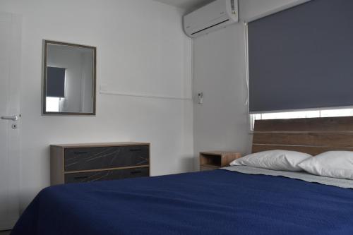 普罗塔拉斯Maria Holiday Apartments的一间卧室配有蓝色的床和镜子