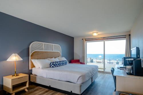 林肯市Seagull Beachfront Inn的一间卧室配有一张床、一张书桌和一个窗户。