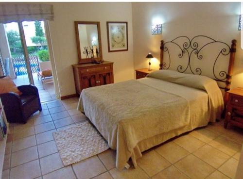 维拉摩拉Citadela I, Golfe, Pool and Falesia Beach的一间卧室配有一张床、一把椅子和镜子