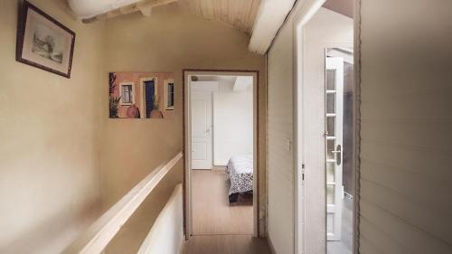 勒宝洛ZENSAN Meublé Maison de Village Le Boulou 66160的走廊上设有镜子和一张位于客房内的床