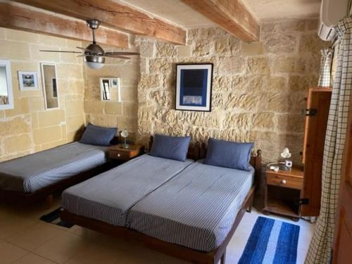 圣劳伦斯Dar Dragun: luxury 3BR bright spacious house & pool的石墙客房的两张床