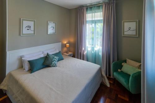 蓬他达维托亚Blue House的一间卧室配有一张床和一把绿色椅子