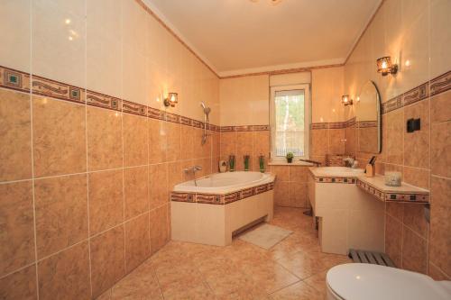 StobnickoKwintesencja Natury的一间带两个盥洗盆、浴缸和卫生间的浴室