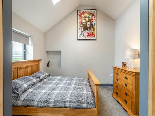 FordwichMayton Lodge的一间卧室配有一张床、一个梳妆台和一扇窗户。