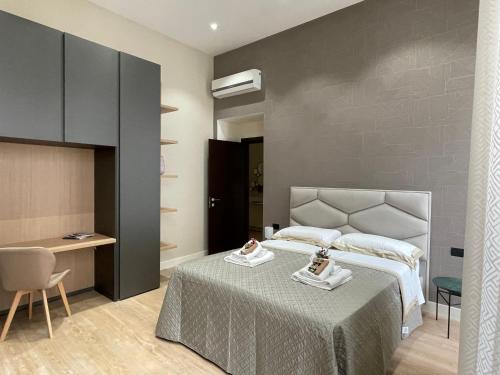 那不勒斯Napoli Mariana Luxury的卧室配有1张床、1张桌子和1把椅子