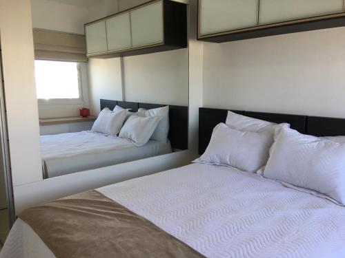 里约热内卢Apartamento Bora Bora Resort的一间卧室配有两张带白色枕头的床