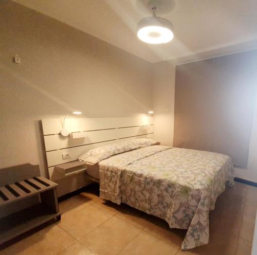 英格兰海滩Apartment Caracol的卧室配有一张床,墙上有灯