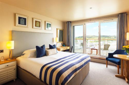 桑德斯富特St Brides Spa Hotel & Village Apartments的酒店客房设有一张床和一个大窗户