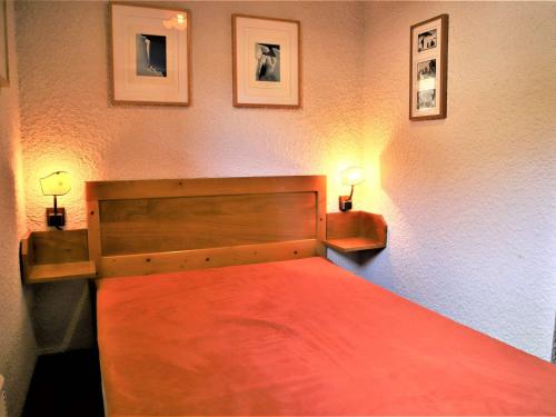 奥瑞斯Appartement Auris, 2 pièces, 4 personnes - FR-1-297-133的一间卧室配有一张红色的床和两盏灯