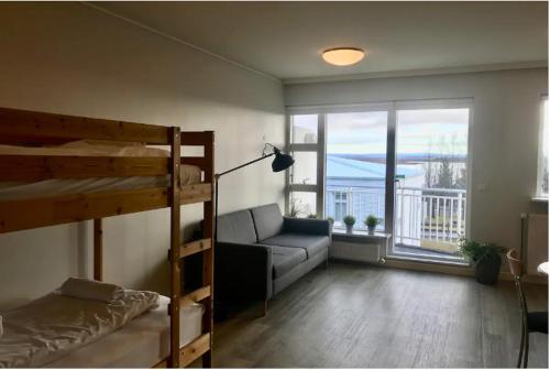 劳加尔瓦特恩Laugarvatn Apartment的客厅配有双层床和沙发。